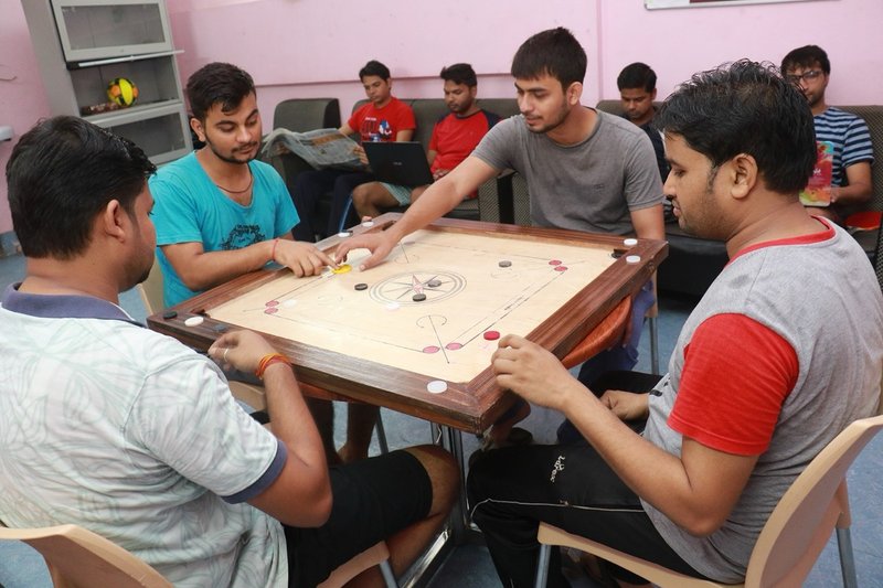 Participants playing carrom in the hostel common room